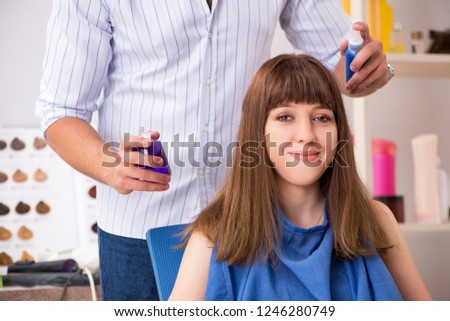 Young woman visiting young handsome barber