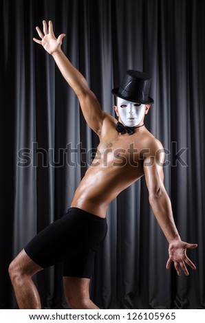 Muscular actor with mask against curtain