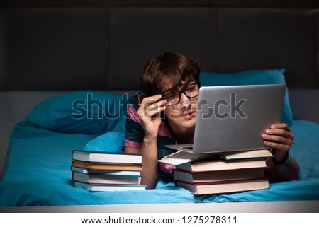 Young student preparing for exams at night at home