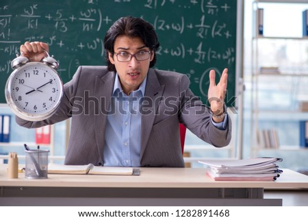 Young handsome math teacher in classroom