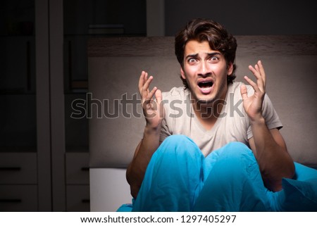 Young man scared in his bed having nightmares