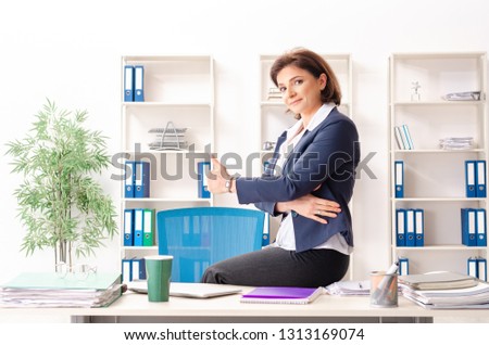 Middle-aged female employee sitting at the office