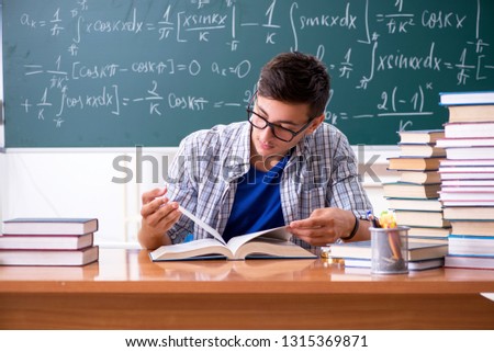 Young male student studying math at school