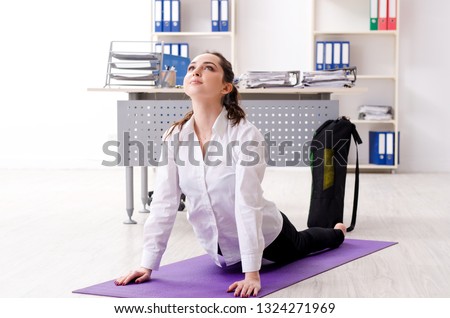 Female employee doing sport exercises in the office