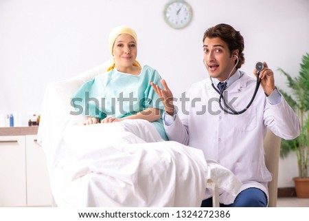 Young handsome doctor visiting female oncology patient