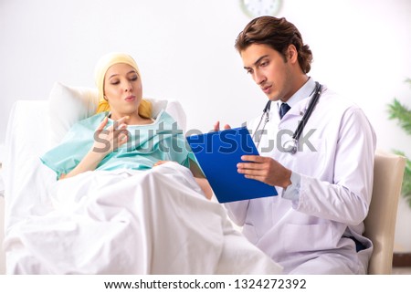 Young handsome doctor visiting female oncology patient