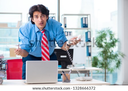 Handsome businessman unhappy with excessive work in the office