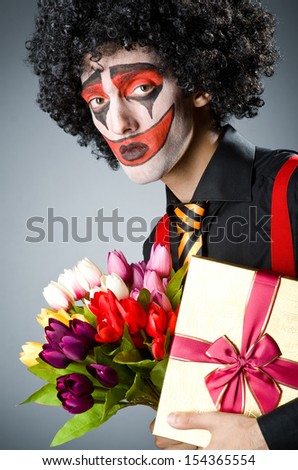Sad clown with the flowers