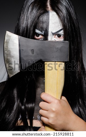 Scary woman with metal axe in halloween concept