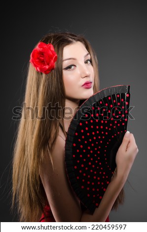 Beautiful young woman with flower and fan