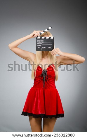 Woman with movie board wearing red dress