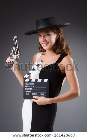 Girl with gun and clapperboard isolated on white