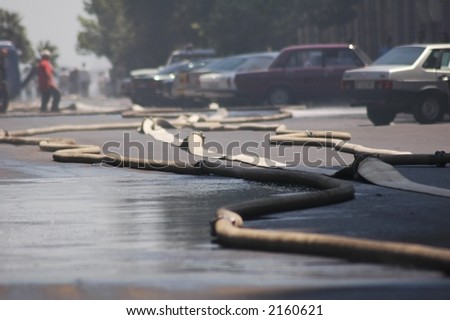 Fire hoses stretching across the street during fire in the city