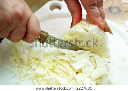 Pair of hands chopping white cabbage