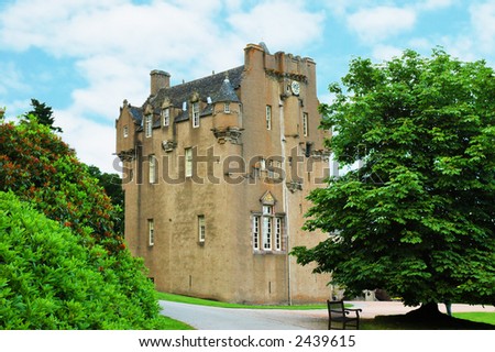 Scottish castle between the trees in summer day