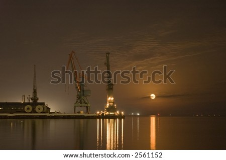 Cranes in the port and reflection of moon in the water - Baku, Azerbaijan