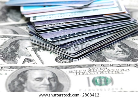 Stack of  credit cards and dollar bank notes