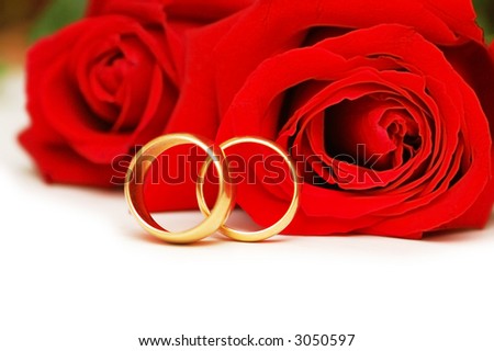 stock photo Two wedding rings and red roses isolated on white