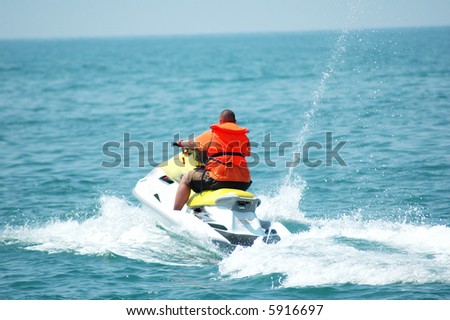 Man driving a motorised scooter at sea - more similar photos in my portfolio