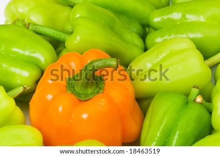 Stand out from crowd concept with green and orange pepper