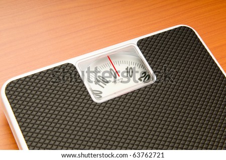 Dieting concept with scales on the wooden floor