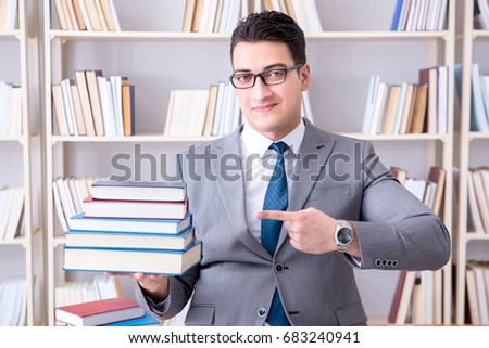 Business law student with pile of books working in library