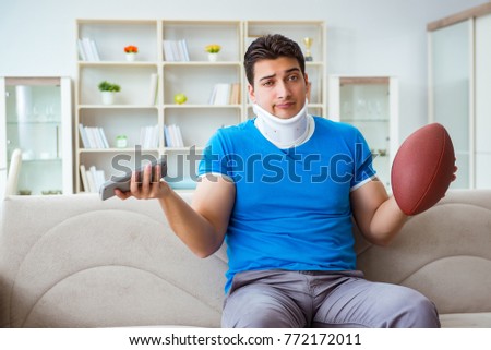 Man with neck injury watching american football at home