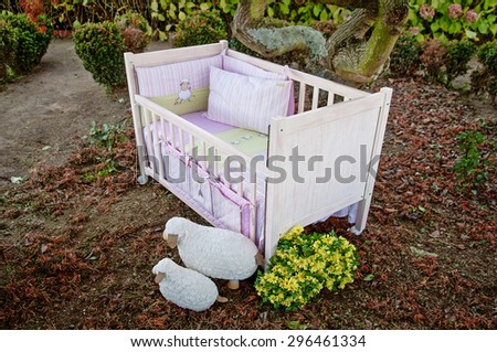 pink baby cot bed in romantic garden