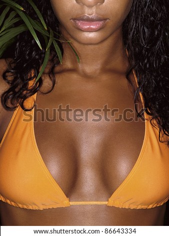 stock photo photo of african girl breasts in orange bikini with tropical 