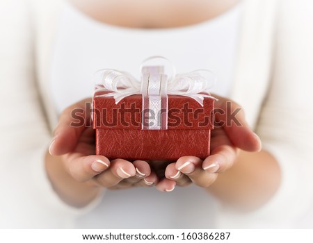Hands holding beautiful gift box, female giving gift, Christmas holidays and greeting season concept, shallow dof