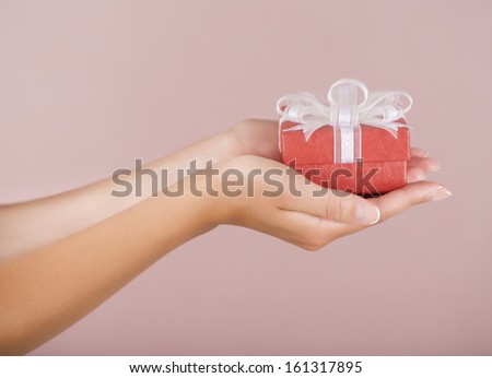 Hands holding beautiful gift box, female giving gift, Christmas holidays and greeting season concept, shallow dof