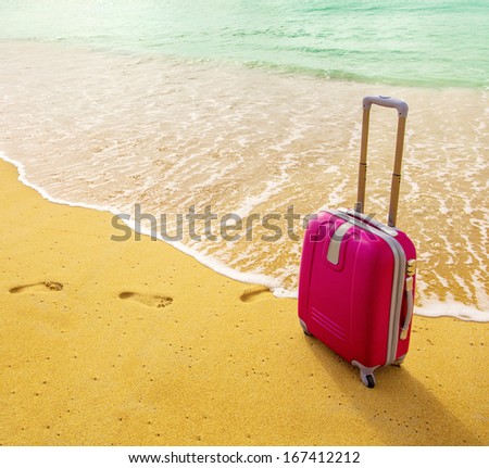 Travel Suitcase Is Alone On A Beach With The Lake Or Ocean In The Background.