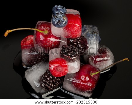 Fresh fruits frozen in ice cubes isolated on black background. Fresh healthy summer eating.