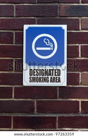 Smoking area sign on a brick wall
