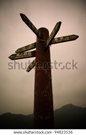 direction sign pointing multiple directions with chinese and english names of places in Hong Kong, namely lantau peak, wanshan islands, fan lau, tai a chau, shek kwu chau and macau