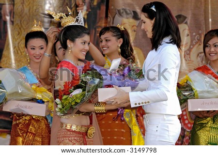 Miss Universe 2005, Natalie Glebova presenting a prize to a beauty contest winner