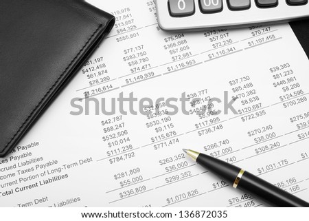 business financial chart analysis with pen, wallet & calculator on paper work