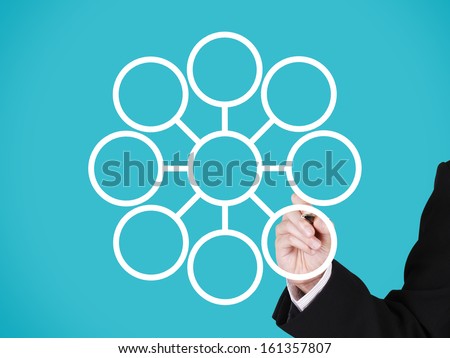 businessman writing on blank circular marketing network, blue background