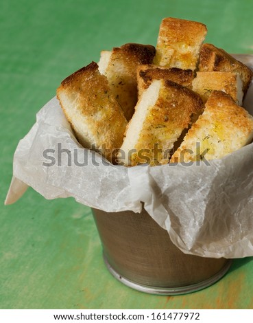 Garlic Bread. Toast bread slices in strips in metal pot.