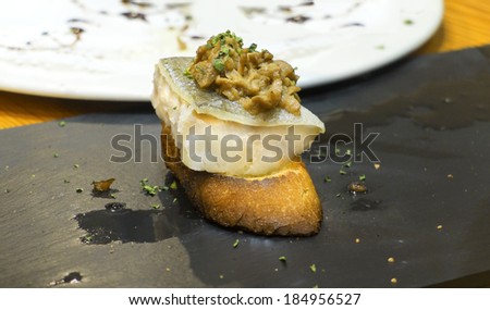 Typical spanish codfish pincho cooked at low temperature in slate plate.
