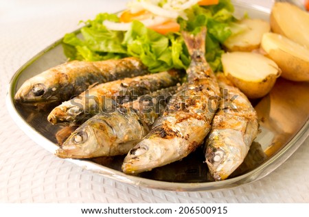 Grilled sardines with mediterranean salad and boiled potatoes. Typical mediterranean dish.
