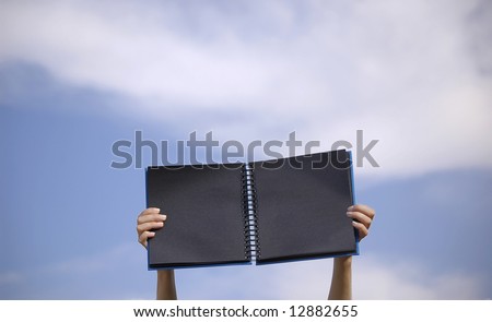 Black notebook in a blue sky