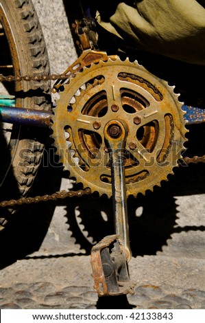 Close-up Cycle chain, pedal and gearwheel chainring grungy and rusty