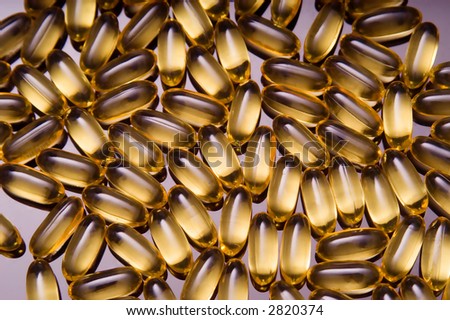 Closeup of a pile of vitamin gel capsules.