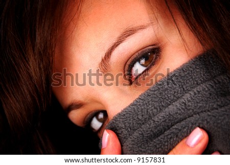 A woman\'s face with a sweater pulled up to her eyes.
