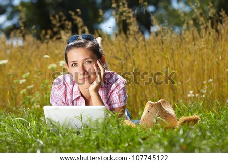 Happy attractive female work on her laptop, summer outdoor shoot