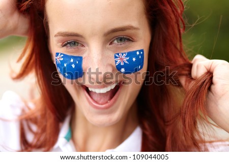 Happy female with Australian flag and small flags on his cheeks, isolated