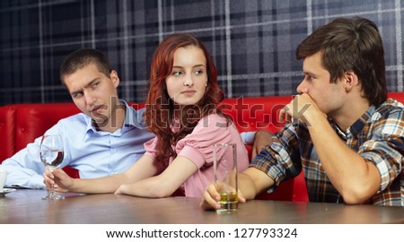 Jealous man looking at his girlfriend sitting in a restaurant