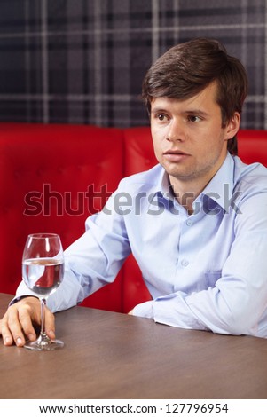 Young handsome man sitting alone in a restaurant