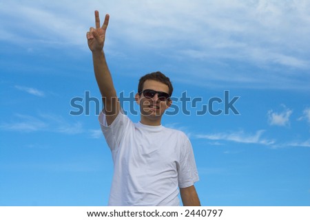 Young male, boy with sunglasses on bright blue sky expressing happiness, victory triumph joy and satisfaction